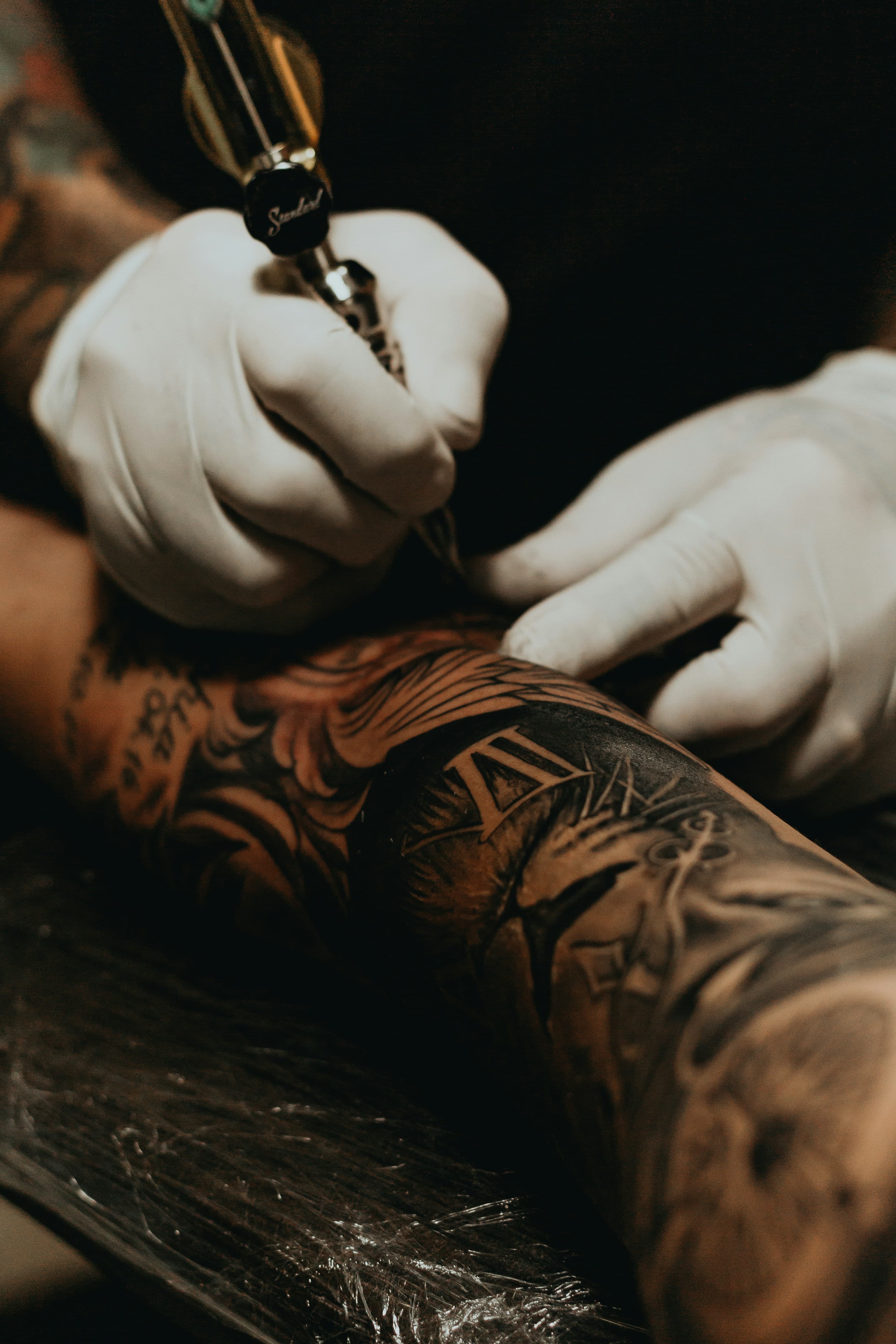 Tattoo artist working on a client’s arm